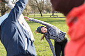 Woman exercising, stretching in park