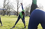 Man stretching, exercising in park