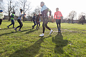 People running, exercising in sunny park