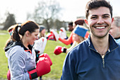 Portrait smiling young man boxing in park