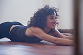 Smiling young female dancer stretching