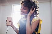 Smiling, carefree young woman listening to music
