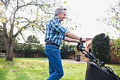 Senior man moving lawn with lawnmower