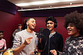 Smiling teenage boy musicians recording music