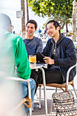 Male friends at sidewalk cafe