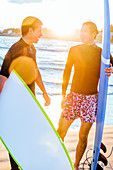 Male surfers with surfboards talking