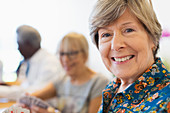 Senior woman playing cards with friends