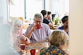 Senior friends playing games and drinking tea