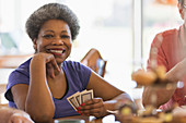 Portrait smiling, senior woman playing cards