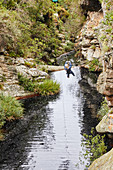 Woman zip lining over stream