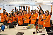Portrait hackers cheering, coding at hackathon