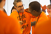 Happy hackers hugging, coding at hackathon