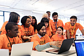 Happy hackers at laptop coding at hackathon