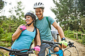 Happy, affectionate young couple mountain biking