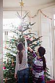 Mother and daughter decorating Christmas tree