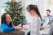 Family opening Christmas gifts in living room
