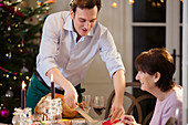 Son serving Christmas turkey to senior mother