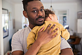 Father holding tired baby son