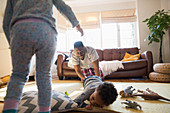 Playful father and children in living room