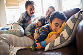 Mother and children cuddling on sofa