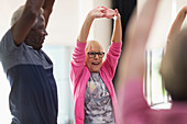 Active seniors stretching arms