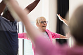 Active senior woman stretching arms