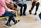 Active seniors stretching, exercising with straps