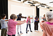 Active seniors stretching arms and back in circle