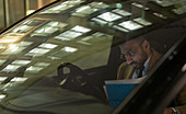 Businessman reviewing paperwork in car at night