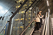 Business people talking on escalator at night