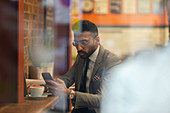Businessman using smart phone, working in cafe