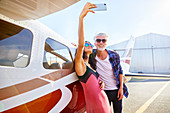 Couple taking selfie at small airplane