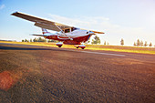 Prop airplane landing on sunny tarmac