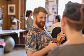 Smiling creative businessman playing ukulele