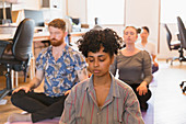 Serene creative business people meditating