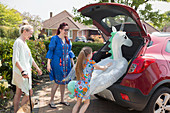 Lesbian couple and daughter loading car