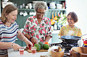 Senior women friends cooking in kitchen