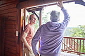 Father and son talking at cabin patio doorway