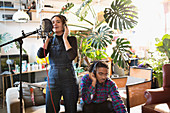 Young man and woman recording music in apartment