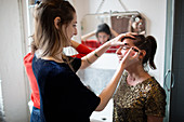 Young women getting ready, applying makeup