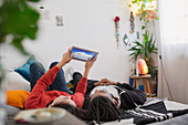 Young couple relaxing, using digital tablet on bed