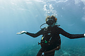 Portrait young woman scuba diving underwater