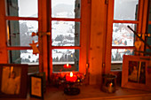 Christmas candle in window in snowy landscape