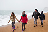 Family walking on snowy winter beach