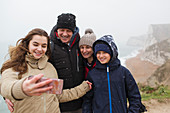 Snow falling over family taking selfie