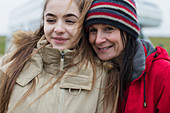 Smiling, mother and daughter in warm clothing