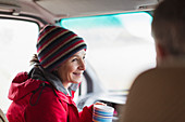 Smiling woman drinking coffee in motor home