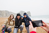 Happy family posing for photograph on beach