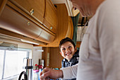 Happy father and son cooking in motor home