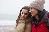Mother and daughter on snowy winter beach